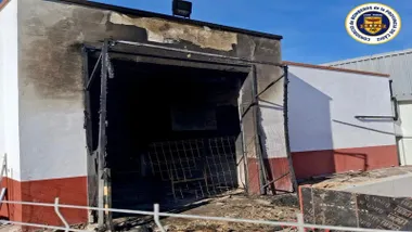 Nave con restos negros del incendio en su puerta de acceso.