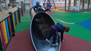 Dos niños juegan en un parque infantil de Cádiz.