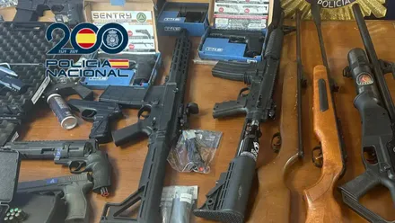 En la imagen se observan varias armas de aire comprimido, munición y 28.000 euros en efectivo, junto a la cartelería policial del Ministerio del Interior que autentifica la operación.