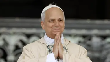 El papa León XI con las manos unidas en señal de oración.