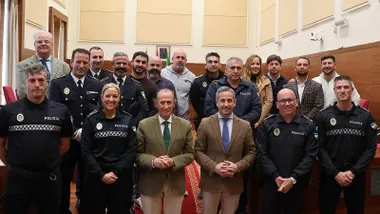 José María Román y José vera junto a los tres nuevos agentes de la Policía Local, están rodeados de otras personas.