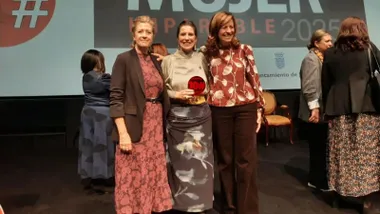 Tres mujeres posan delante de una pantalla de los premios Imparables 2025.