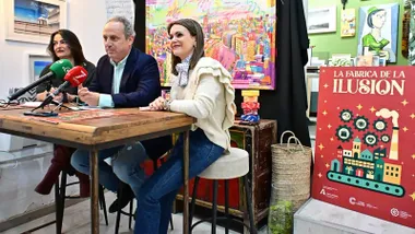 Representantes del Cádiz Centro Comercial Abierto y del Ayuntamiento durante la presentación oficial de “La Fábrica de la Ilusión”, con el cartel de campaña y ambiente festivo en el centro histórico.
