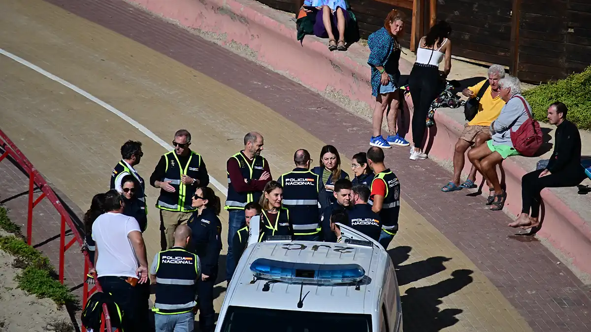 Policía Nacional en Santa María del Mar entre personas curioseando y usuarias de la playa.