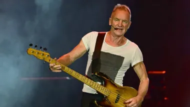 El cantante Sting con su guitarra en plena actuación.