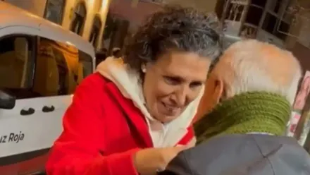 Una voluntaria de Cruz Roja coloca de manera muy cariñosa una de las bufandas a una persona sin hogar de San Fernando.