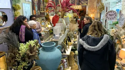 Establecimiento de productos típicos de Rota, con cuadros y jarrones y personas viéndolos.