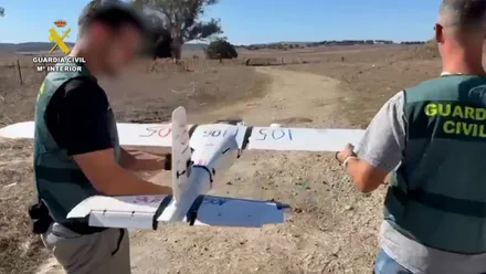 Un dron de la droga sostenido por dos agentes de la Guardia Civil.