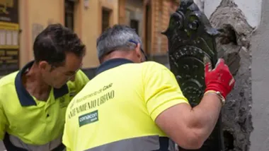 Dos operarios de Mantenimiento Urbano colocan uno de los guardacantones restaurados.