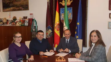 El alcalde de Chiclana firmando los acuerdos con unas personas en el Ayuntamiento.