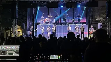 Escenario con los miembros de Alldara Show, con luces de tonos azulados.