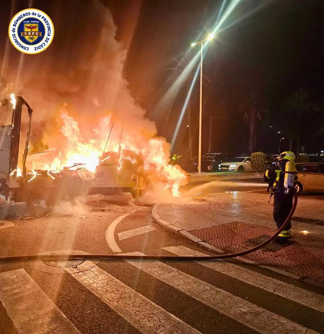 Un bombero trata de apagar el incendio en la furgoneta de reparto. Foto: CBPC.