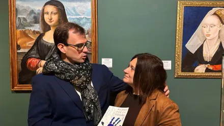 Susana Rivas y Eduardo Martínez posando delante de dos cuadros interpretativos de obras de Arte.