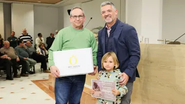 El alcalde de Rota entregando uno de los premios, posa con el premiado y con una niña rubia.