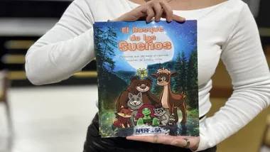 Portada del libro "El bosque de los sueños", sostenido en las manos de una mujer.