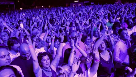 Público en el Caribe Mix Festival con luces rojizas-azuladas.