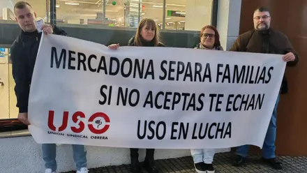 Imagen de una concentración sindical convocada por USO en la entrada del Mercado de Loreto-Puntales, en Cádiz. Varias personas sostienen pancartas en defensa de la conciliación familiar frente a un supermercado Mercadona, en una jornada marcada por la lluvia.