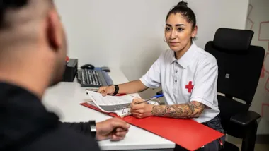 Chica de la Cruz Roja hablando con una persona.