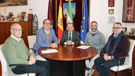 Momento de la firma del acuerdo en Chiclana, personas sentadas en torno a una mesa mirando a cámara.