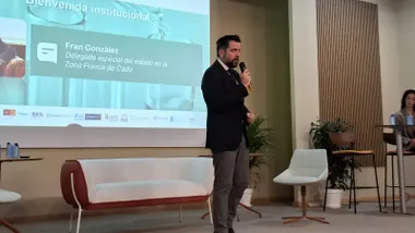 Fran González ofrece su discurso de cierre en la jornada final del proyecto IberoBio, con carteles institucionales de Zona Franca, FEDER e Interreg España–Portugal al fondo.