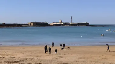 Vista del Castillo de San Sebastián captada desde la playa de La Caleta, con la marea baja
