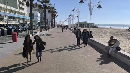 Varias personas caminan por el Paseo Marítimo de Cádiz en una soledada jornada de otoño.
