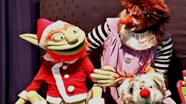 Marioneta del "Grinch" siendo manejada en el escenario.