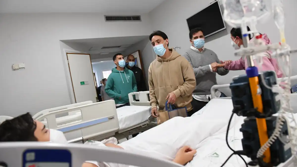 Iza se acerca a entregarle un regalo a un pequeño hospitalizado en el hospital Puerta del Mar. Foto: Cádiz Cf