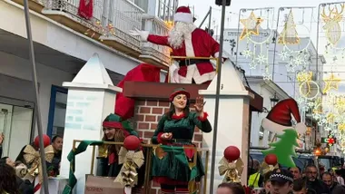 Papa Noel tirando caramelos desde su carroza en San Fernando.