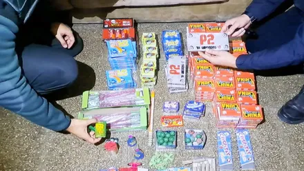 Agentes de la Policía muestran, en el centro, el material incautado de tipo pirotécnico.