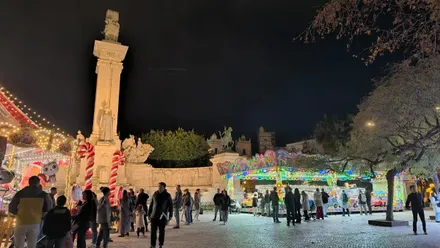El monumento de las cortes de Cádiz con atracciones infantiles por Navidd delante.