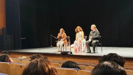 Escenario del Teatro Moderno de Chiclana con "Por Amal" y la delegada Susana Rivas.