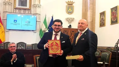 Luis Miguel Quintana Sánchez-Romero sosteniendo un libro rojo.