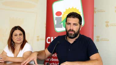 Roberto Palmero junto a Susana Rivas y de fondo el logotipo de IU.