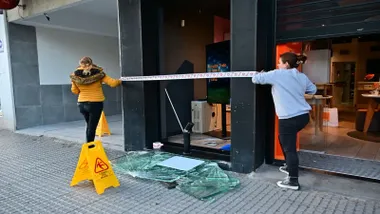 Restos de cristales y el escaparate roto en una tienda de Orange que ha sufrido este robbo