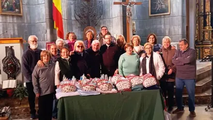 Miembros de "Salvemos la Ilusión" entregando paquetes de comida en una iglesia.