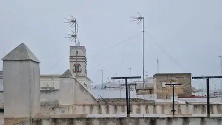 Cielo nublado en una azotea mojada de Cádiz ocn vistas a la Torre Tavira.