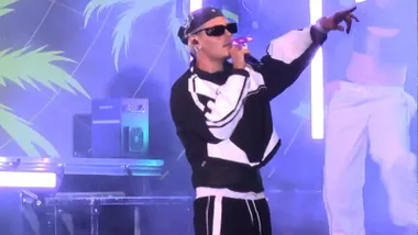 Abraham Mateo cantando con un ropa negra y blanca.