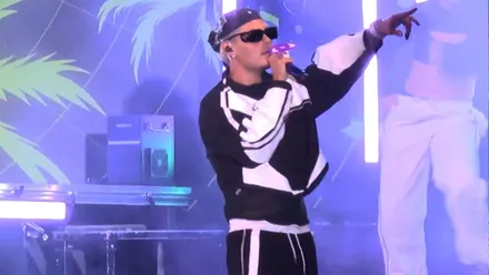 Abraham Mateo cantando con un ropa negra y blanca.