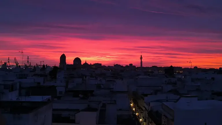 Espectacular amanecer en Cádiz este 2 de enero con las siluetas de la Catedral y el Piruli dibujándose delante del cielo rojizo. Foto: José Luis Porquicho Prada.