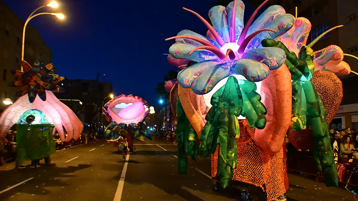 Animación con figuras hinchables y personajes interactuando con el público durante la Cabalgata de Reyes Magos.