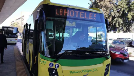 Parada de autobús con un vehículo en amarillo y verde.
