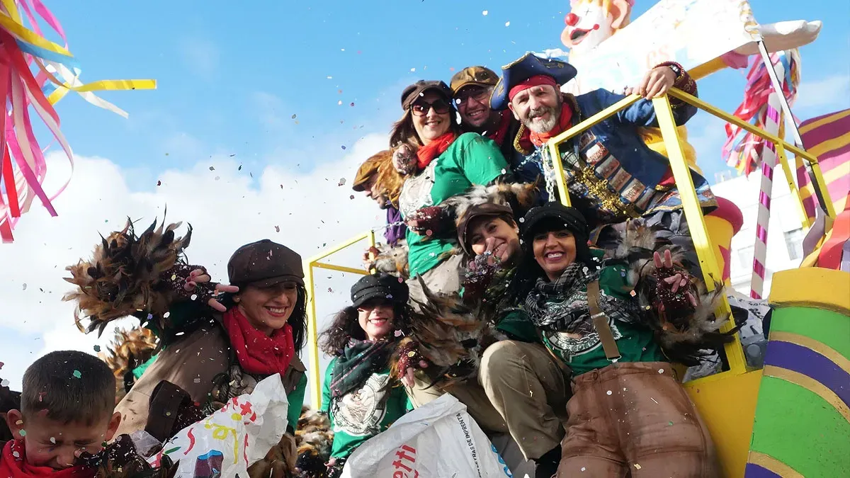 Niños y niñas, con mayores, disfrutando en una carroza disfrazados de piratas.