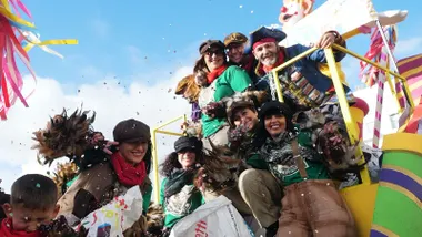 Niños y niñas, con mayores, disfrutando en una carroza disfrazados de piratas.