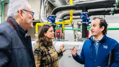 Patricia Cavada en su visita al centro deportivo y a la zona de calderas, viste abrigo de cuadros amarillo y negro.