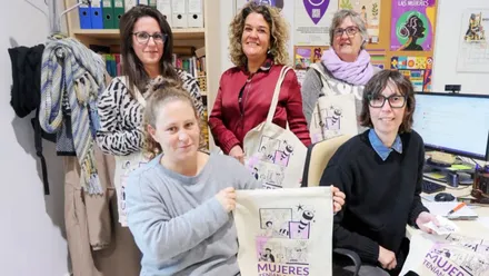 Grupo de mujeres muestran bolsas con el lema "Mujeres tenían que ser".