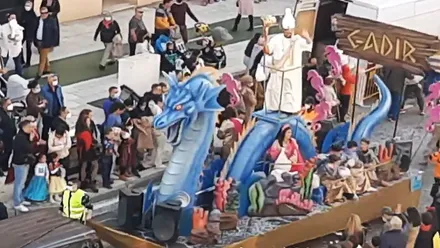 Carroza con un dragón azul y una persona disfrazada de sacerdote fenicio.