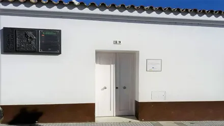 Fachada blanca con una placa en la Casa de Camarón de La Isla.