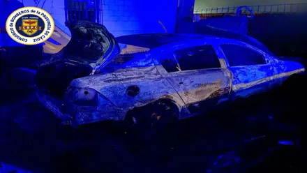 Imagen de noche del coche totalmente calcinado.