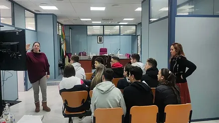 Jóvenes de espalda atienden a una especialista del programa "Educando en Justicia".